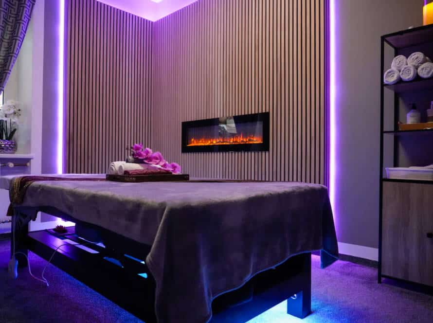 oderner Behandlungsraum für Thai Massage in Nürnberg mit Massageliege und Kamin